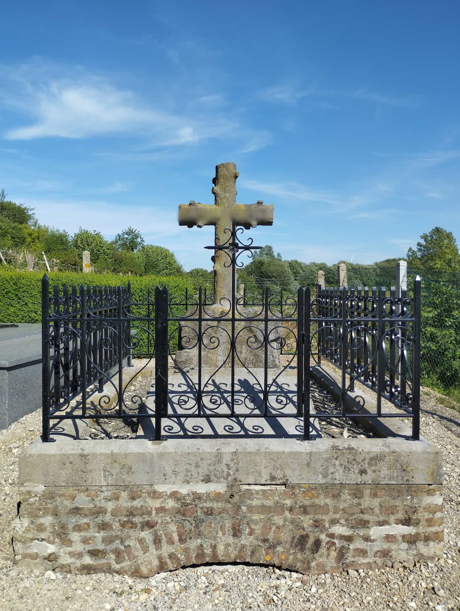 Clôture de tombe en acier vue de face, fixée sur le muret par platines